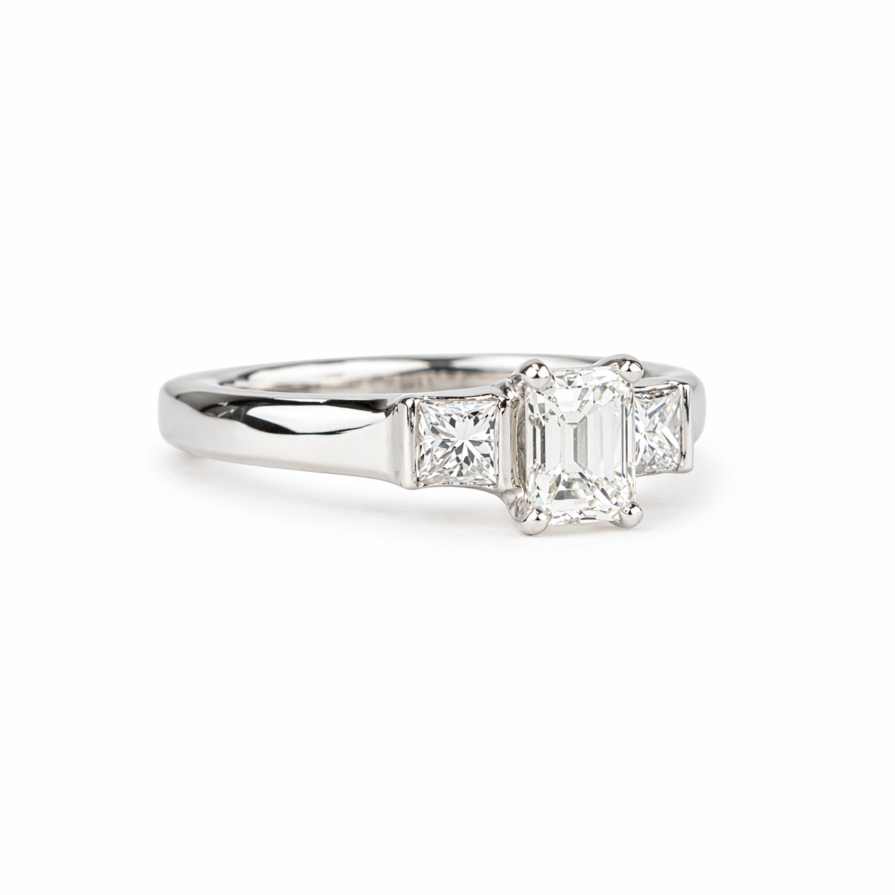 Emerald cut diamond ring with princess cut side stones in platinum