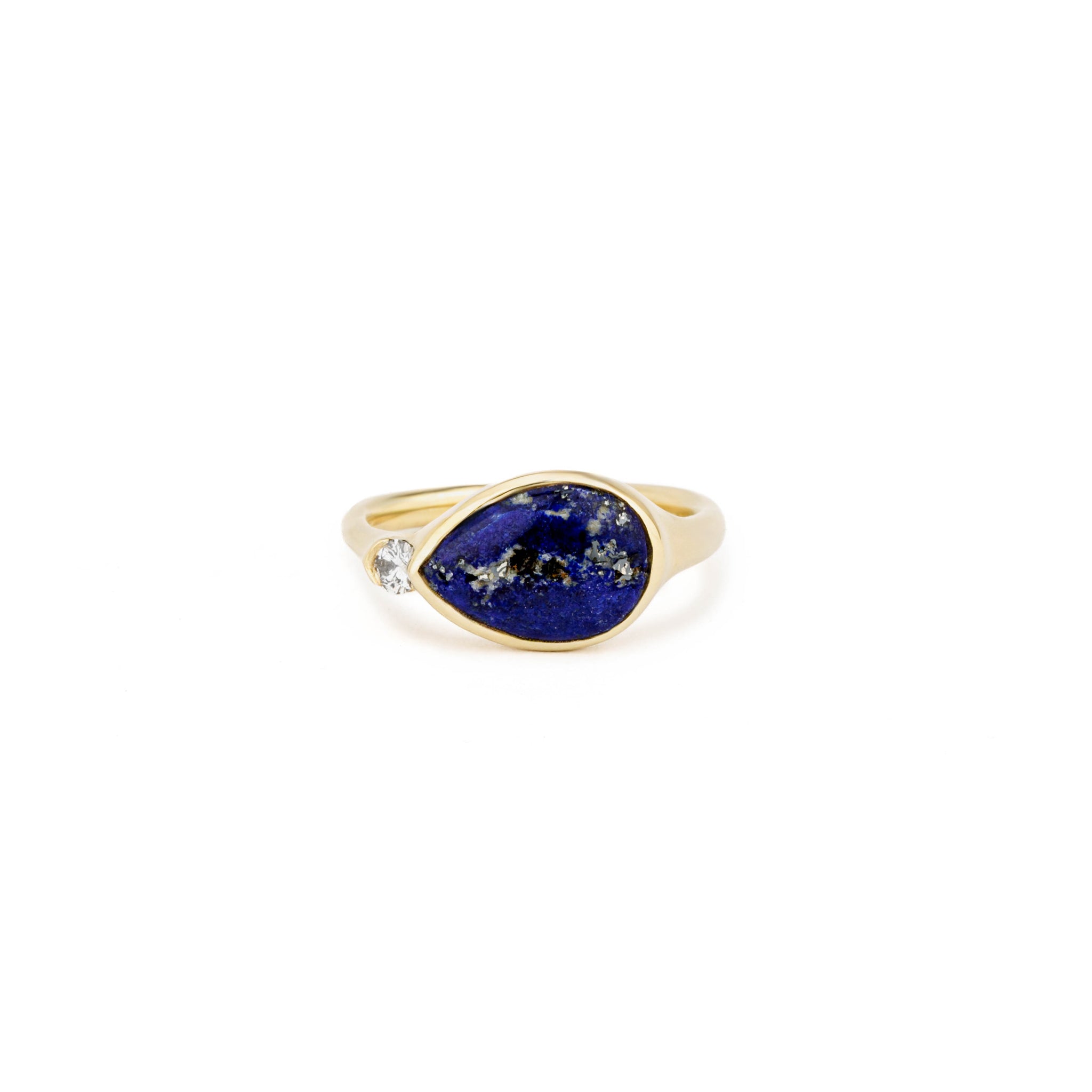 Yellow gold ring with a sideways pear-shaped lapis lazuli cabochon and a single round diamond accent.