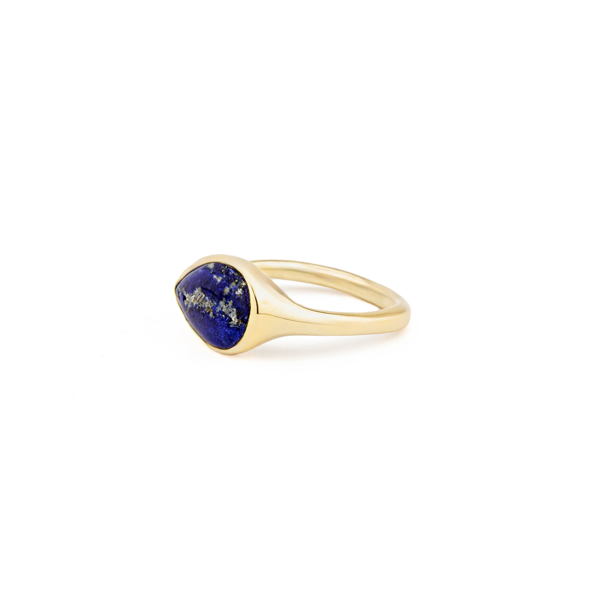 Yellow gold ring with a sideways pear-shaped lapis lazuli cabochon and a single round diamond accent.