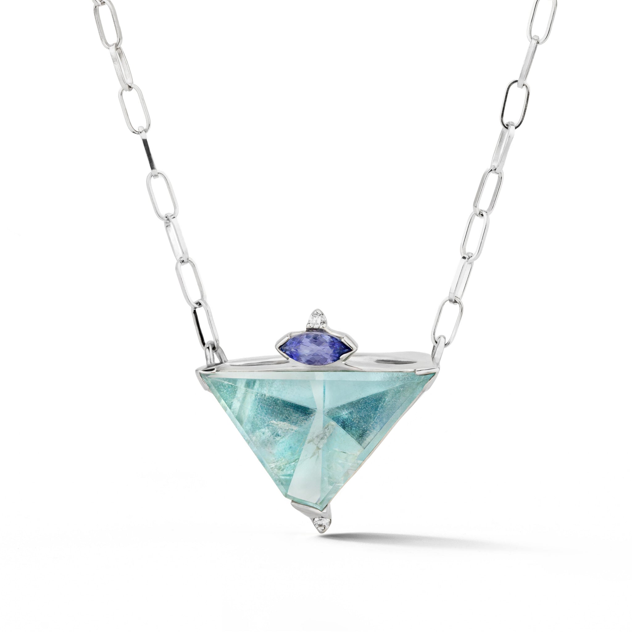 White gold necklace with a large trillion-cut aquamarine pendant accented by a marquise tanzanite and two diamonds, on an oval link chain.