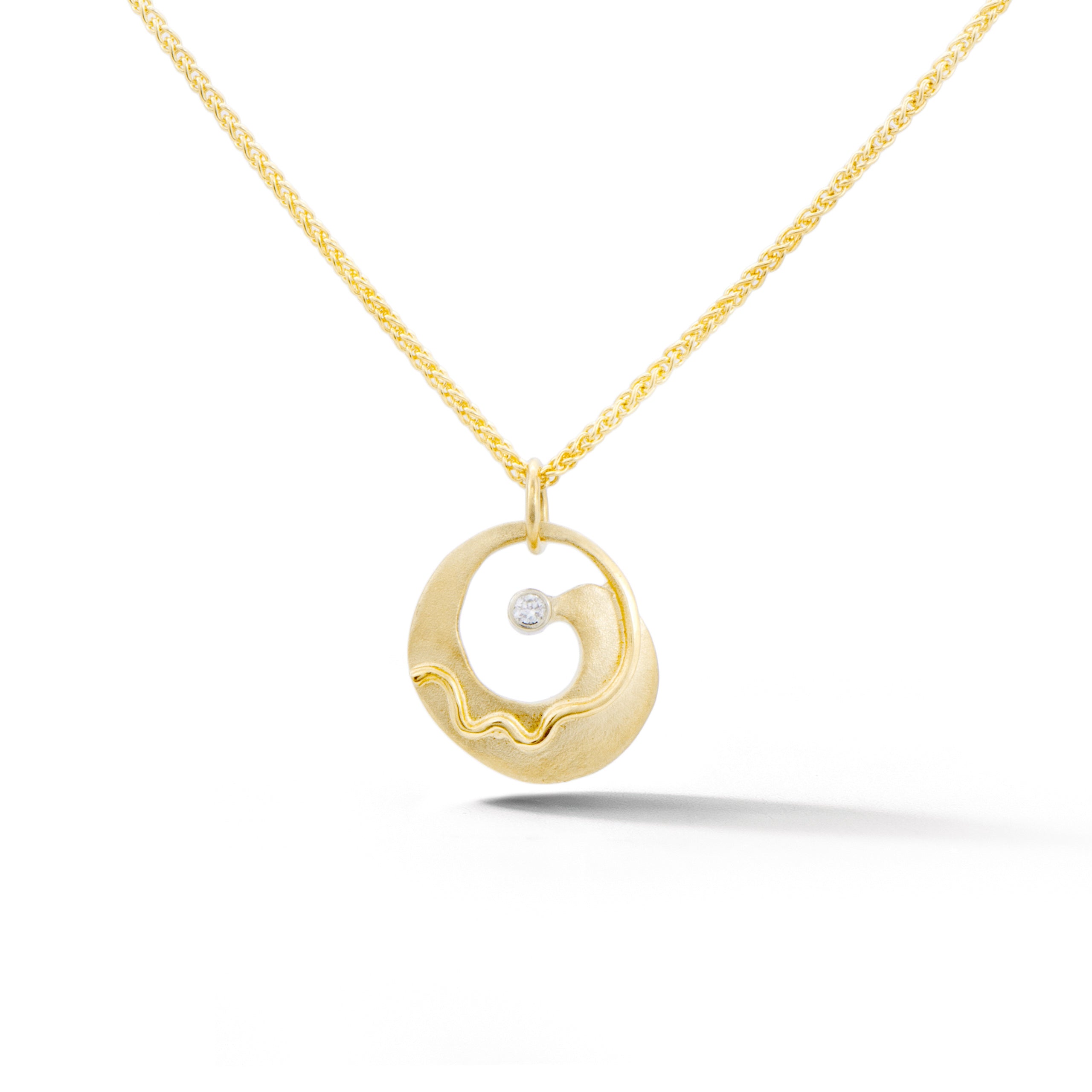 Yellow gold circular pendant with spiral wave design and bezel set diamond