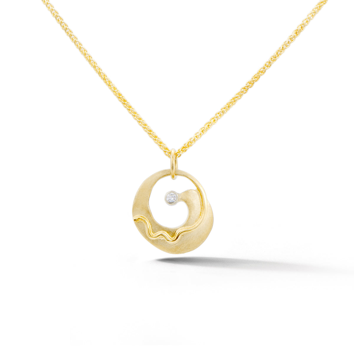 Yellow gold circular pendant with spiral wave design and bezel set diamond
