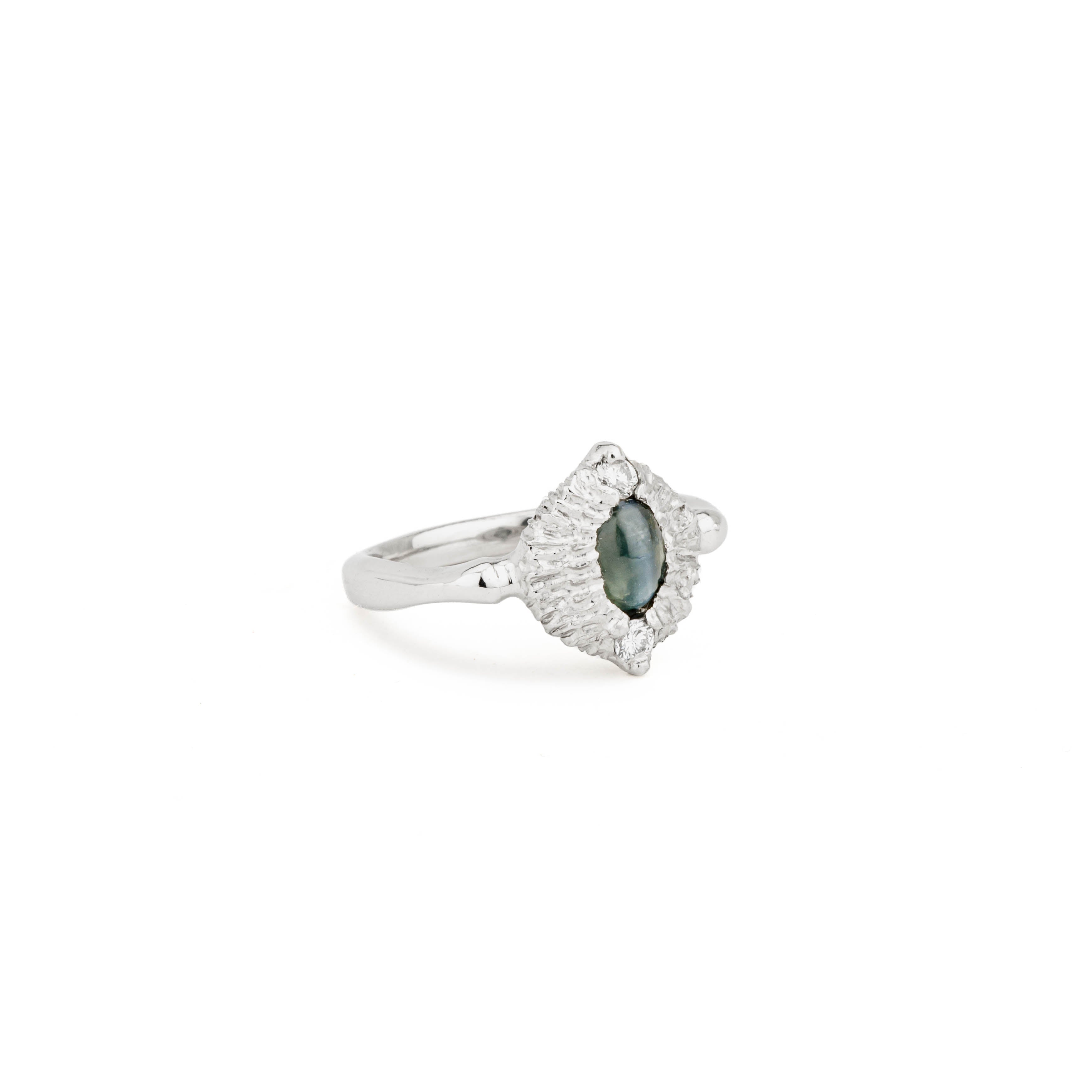 Platinum ring with an oval cat's eye alexandrite cabochon in a textured navette halo, accented by two round diamonds