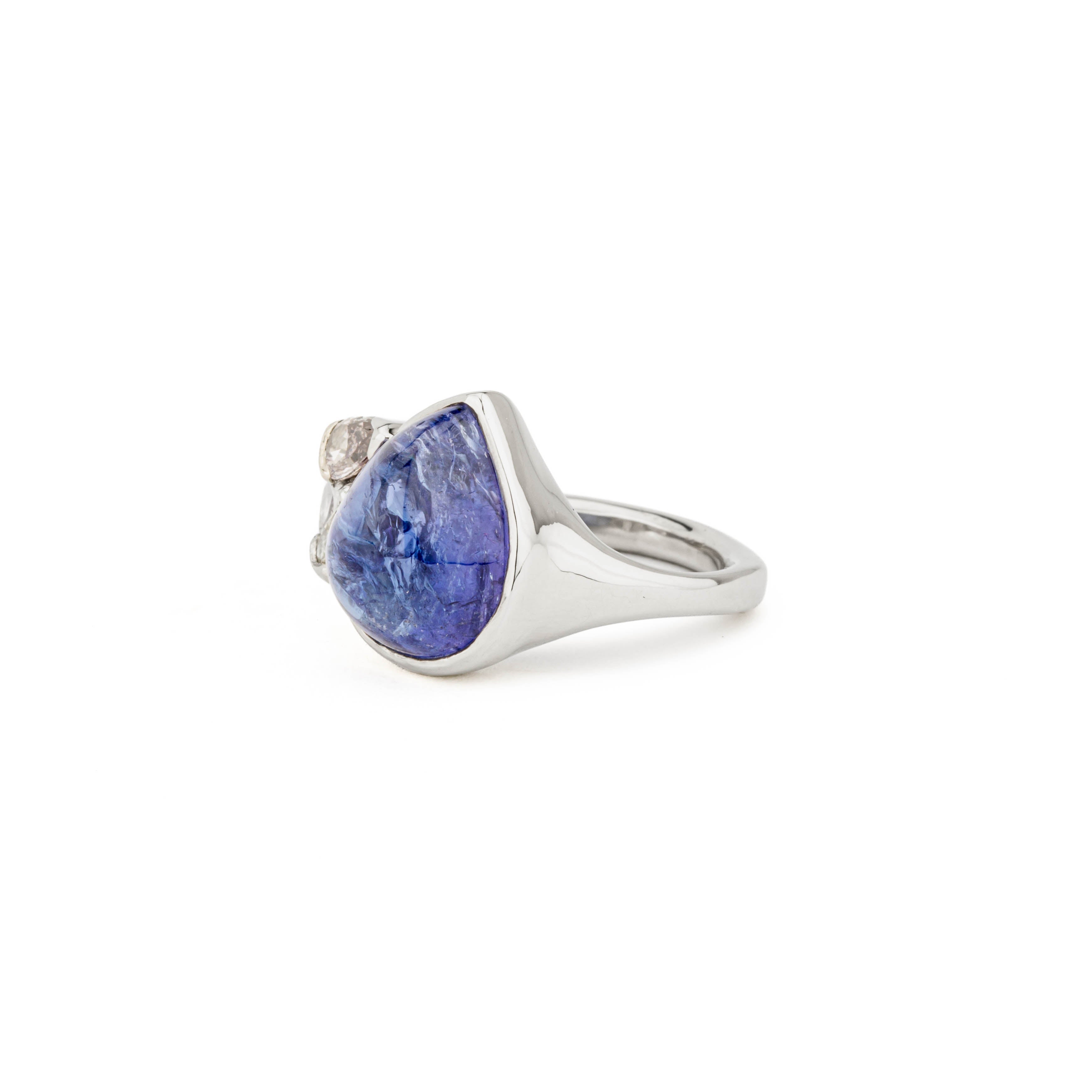 14k white gold ring with a bezel-set pear cabochon tanzanite and three natural fancy color diamonds — canary, pink, and brown — in a v-prong half wrap setting.