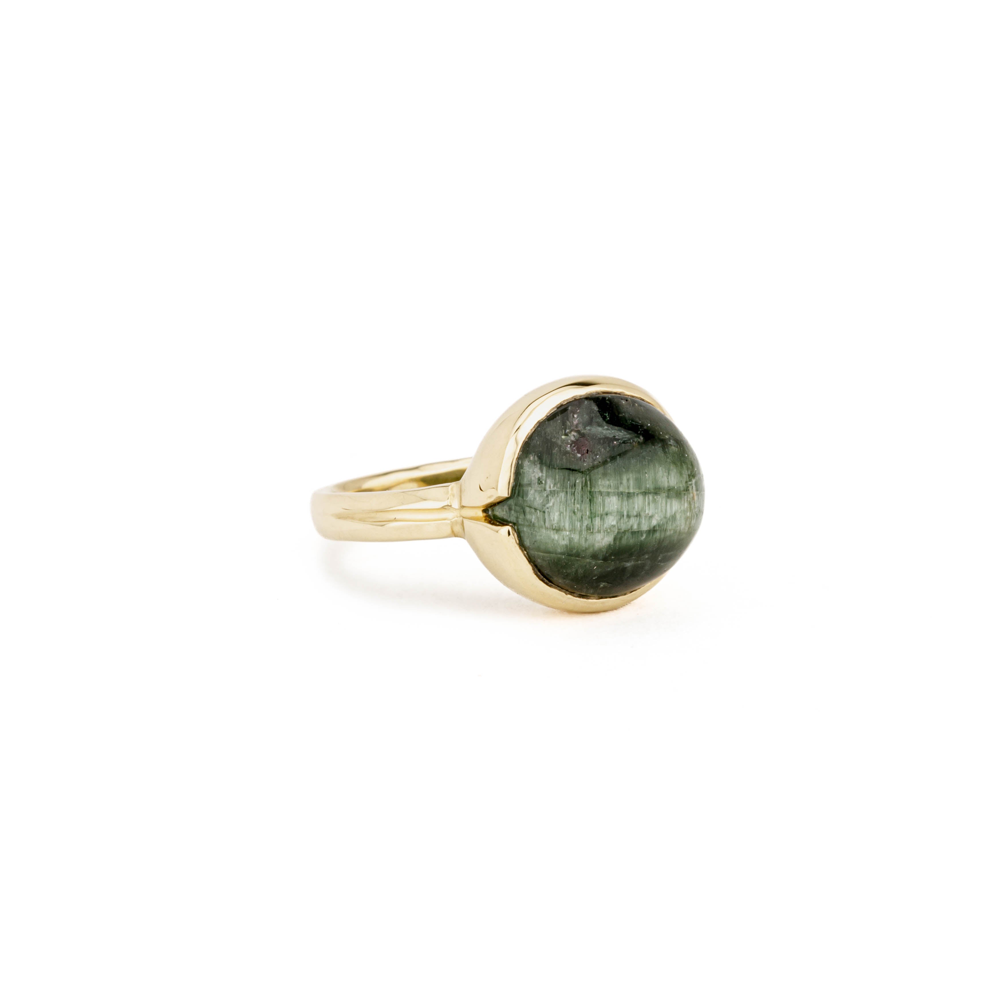 Yellow gold ring with a large round bezel-set cat's eye tourmaline cabochon in deep green