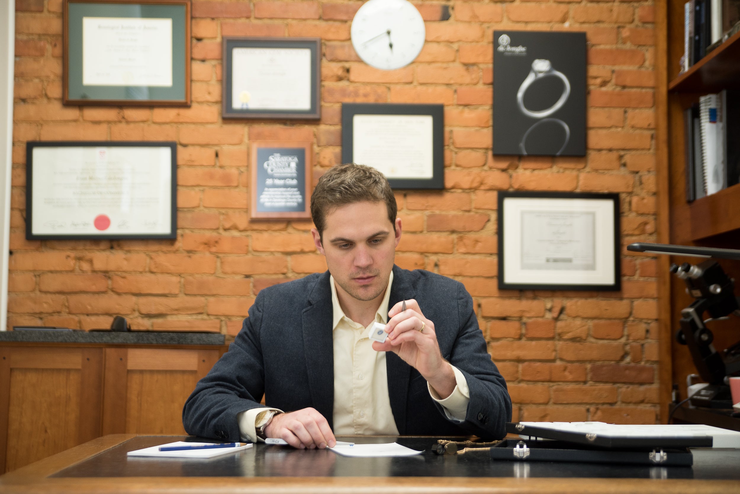 Evan inspecting a gemstone at deJonghe Original Jewelry