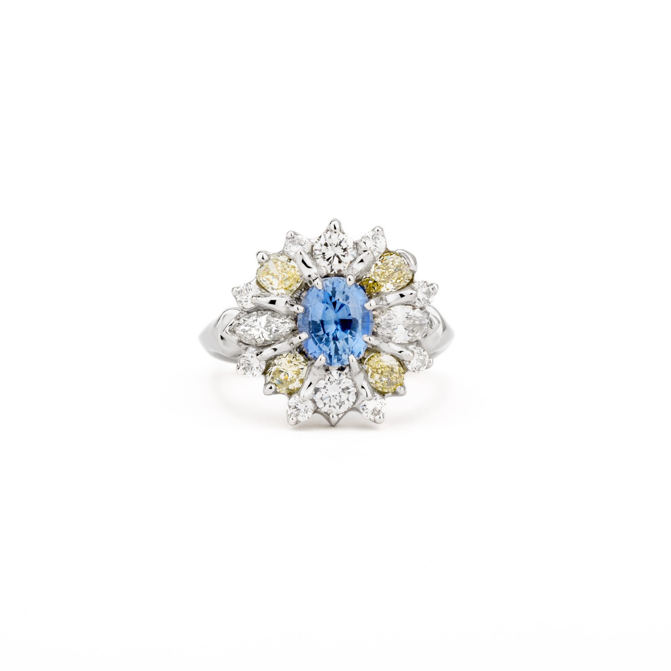 Platinum sapphire cluster ring with blue Ceylon sapphire center and halo of canary yellow and white diamonds