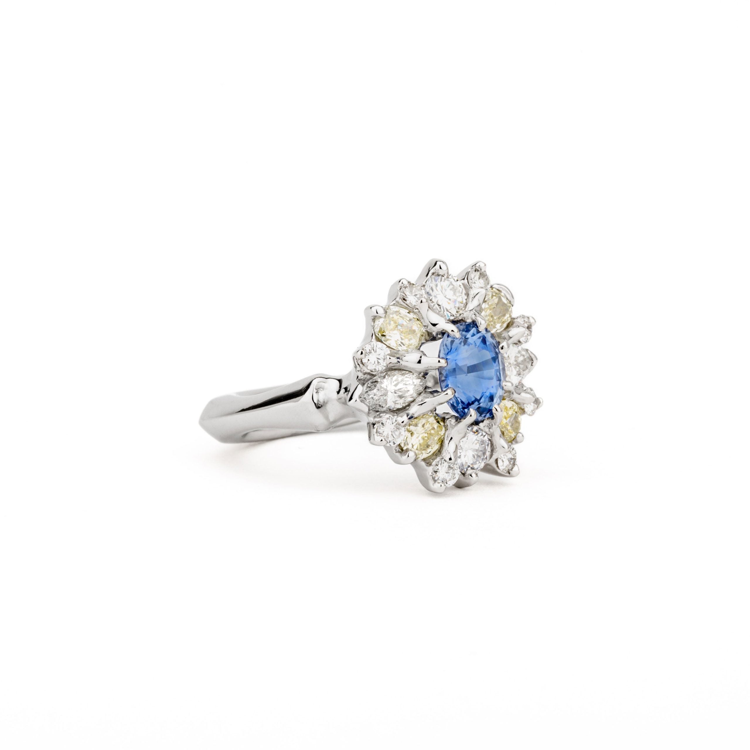 Platinum sapphire cluster ring with blue Ceylon sapphire center and halo of canary yellow and white diamonds
