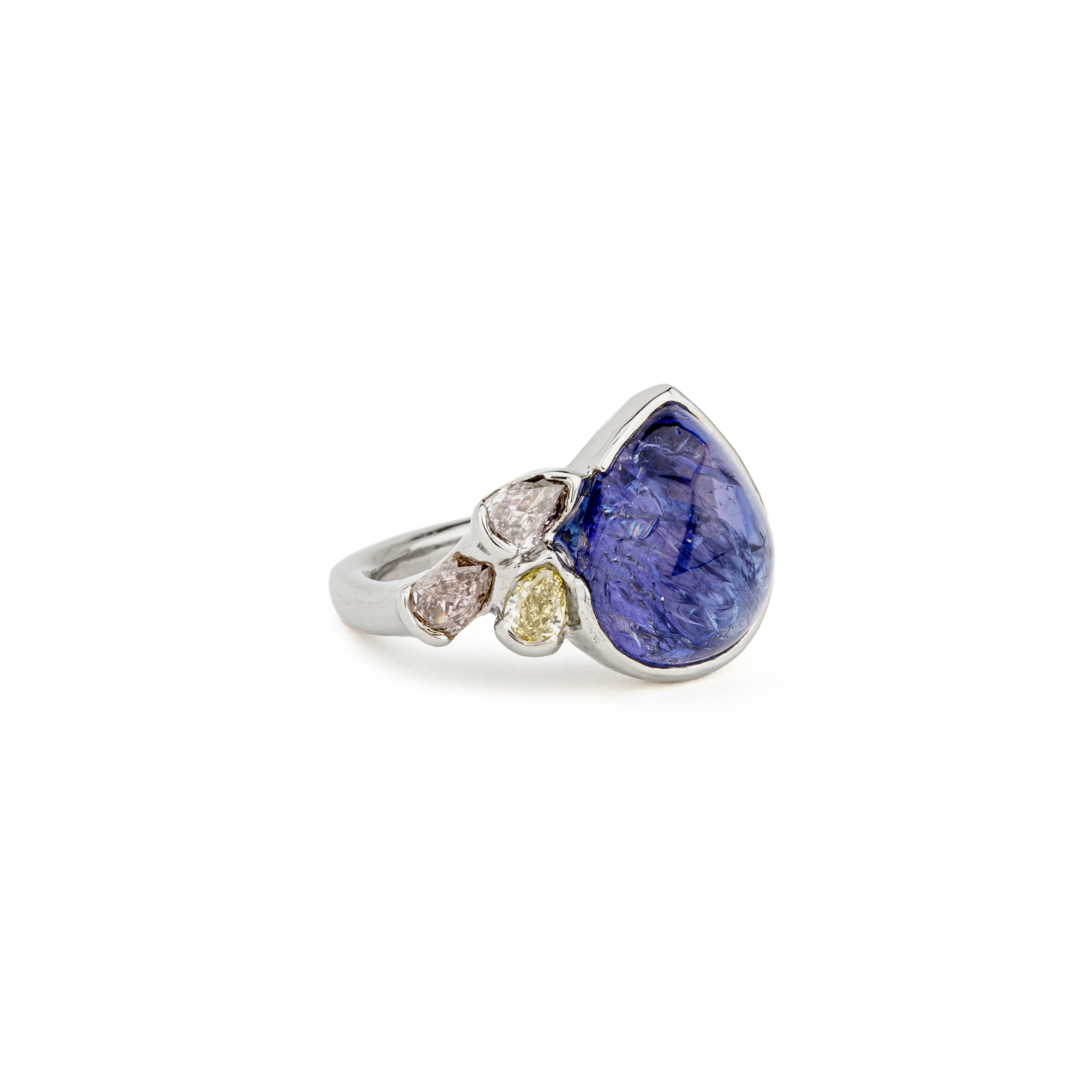 14k white gold ring with a bezel-set pear cabochon tanzanite and three natural fancy color diamonds — canary, pink, and brown — in a v-prong half wrap setting.