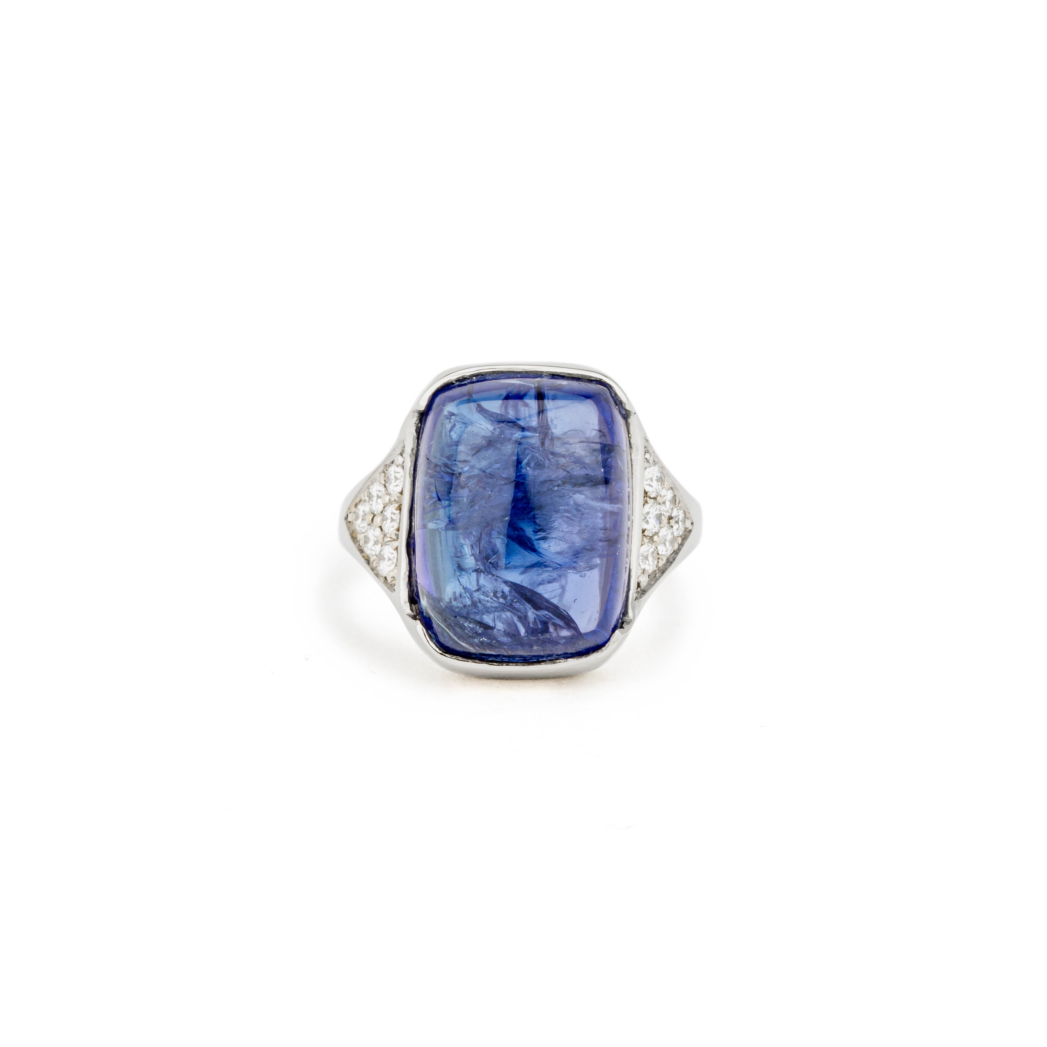 White gold ring with a large cabochon tanzanite in a hand-carved squared setting, flanked by pavé diamond shoulders