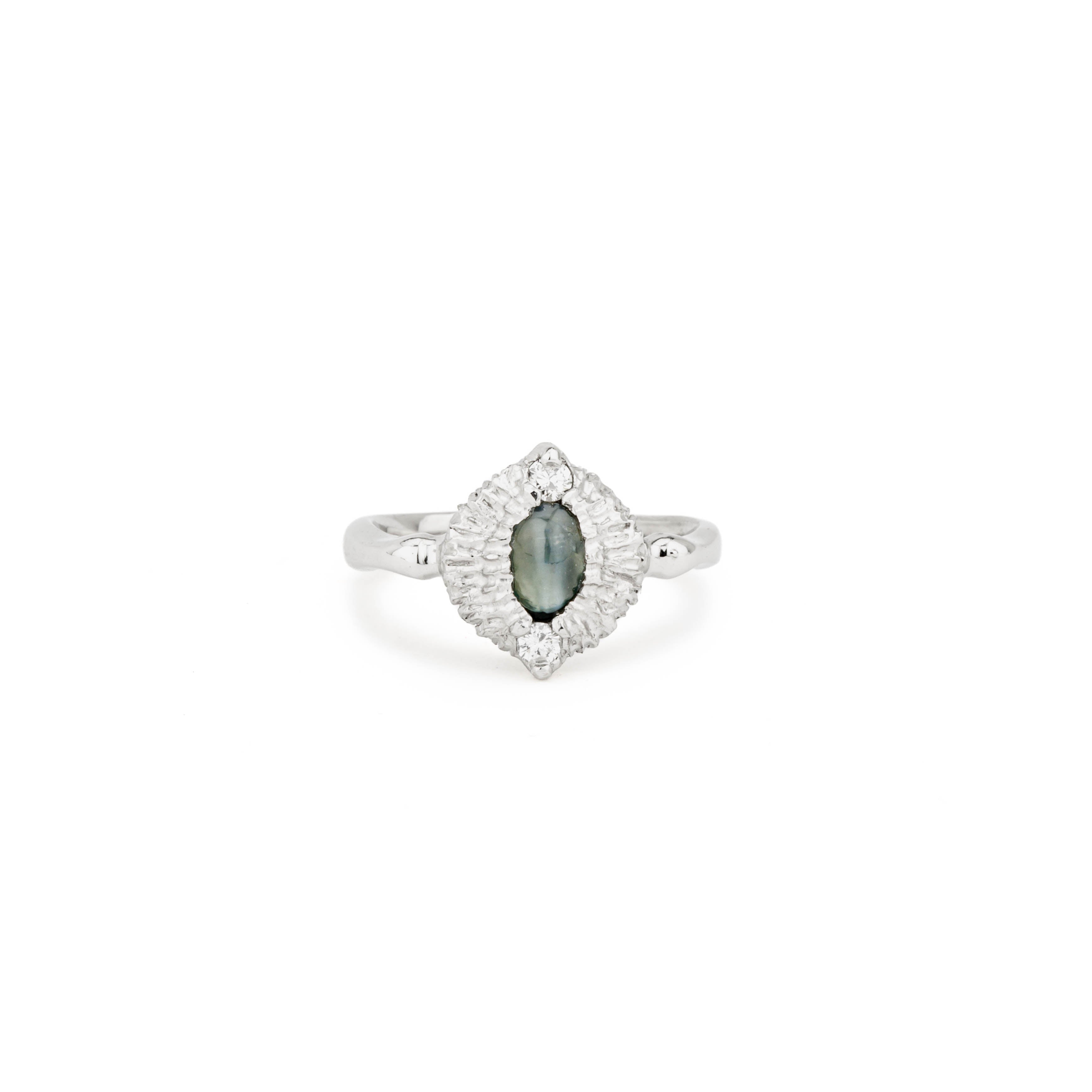 Platinum ring with an oval cat's eye alexandrite cabochon in a textured navette halo, accented by two round diamonds