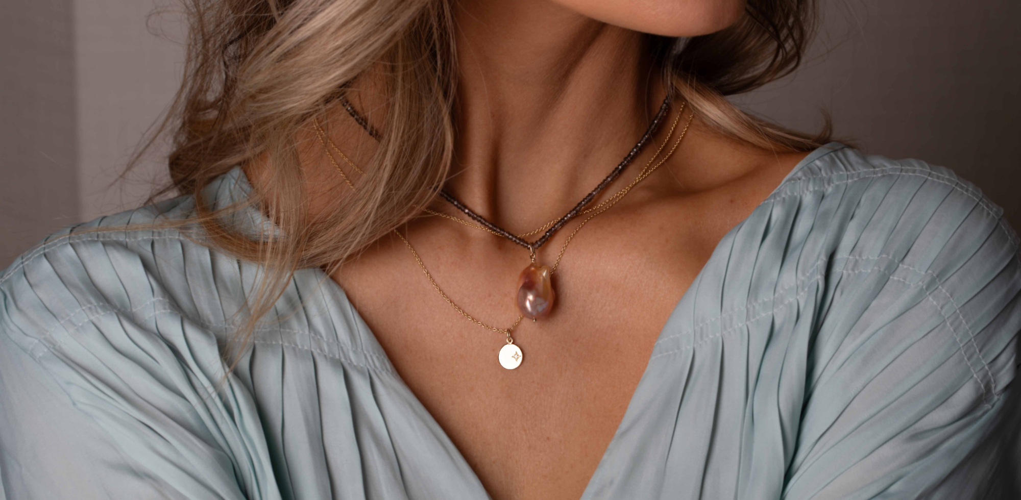 Pearl necklace and a gold necklace by deJonghe Original Jewelry on a model