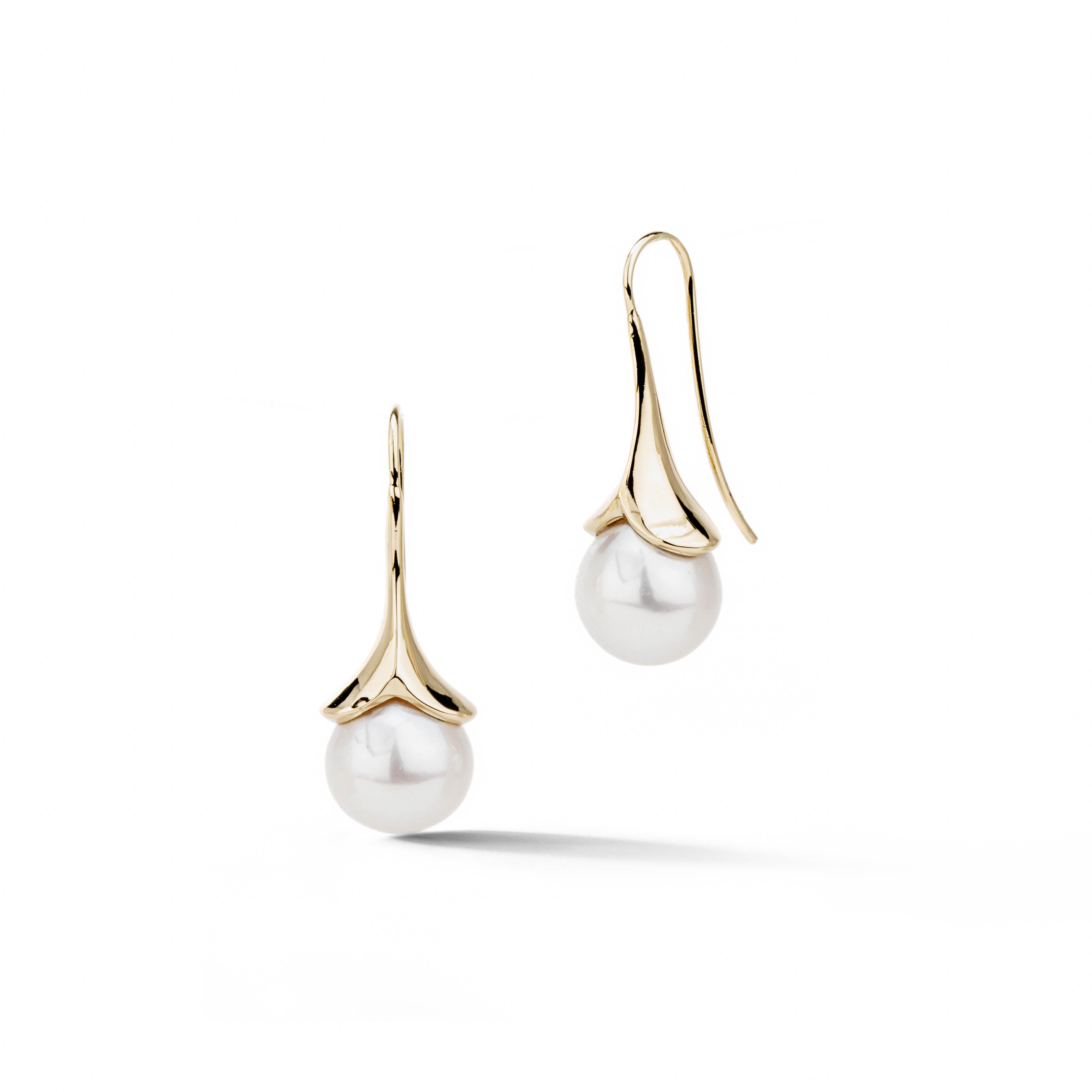 14k yellow gold lily-shaped drop earrings with large round white freshwater pearls on a sage green background, by deJonghe Original Jewelry