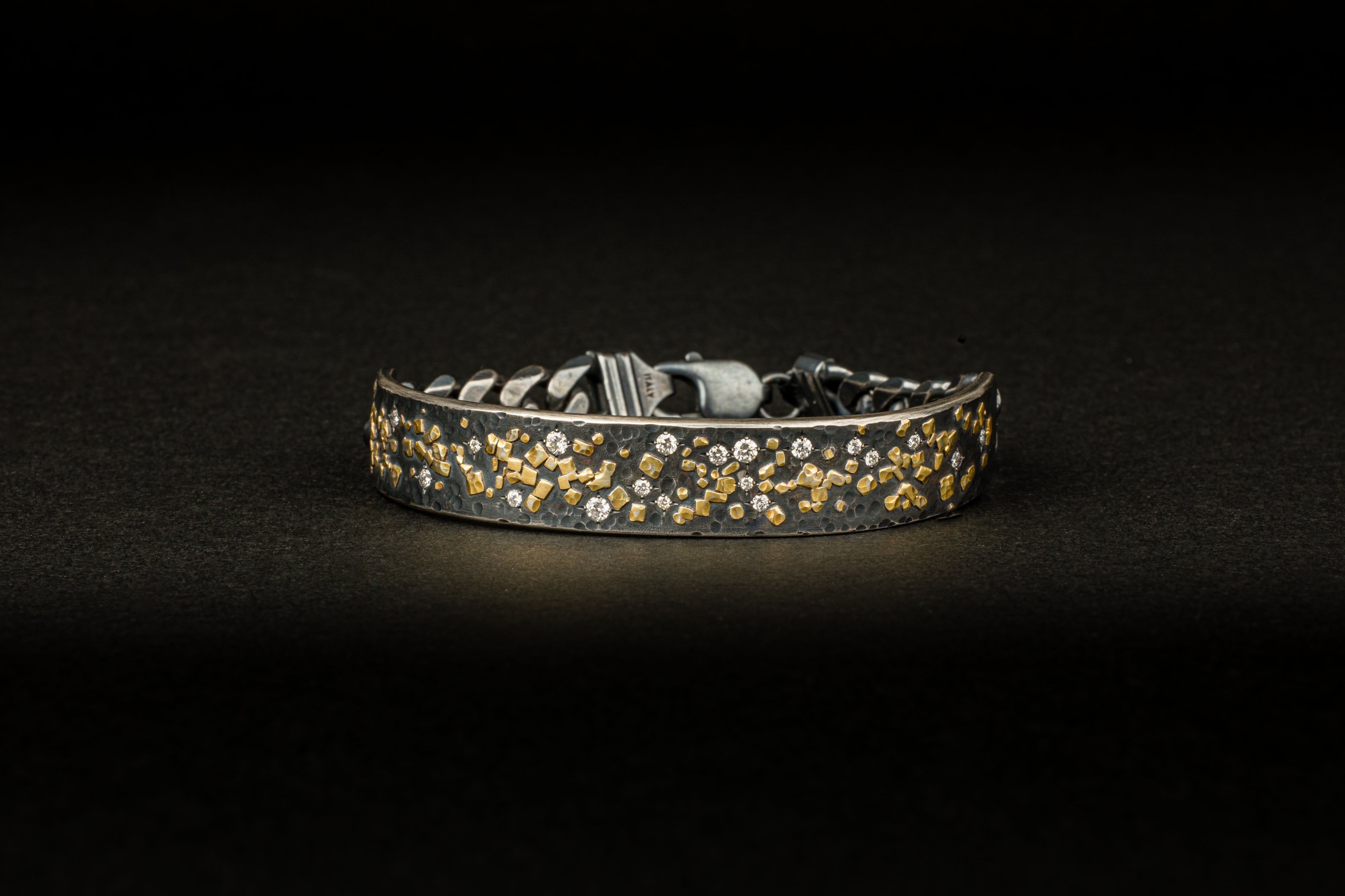  Men's oxidized sterling silver cuff bracelet with scattered 22k yellow gold fragments and round diamond accents, attached to a dark curb chain