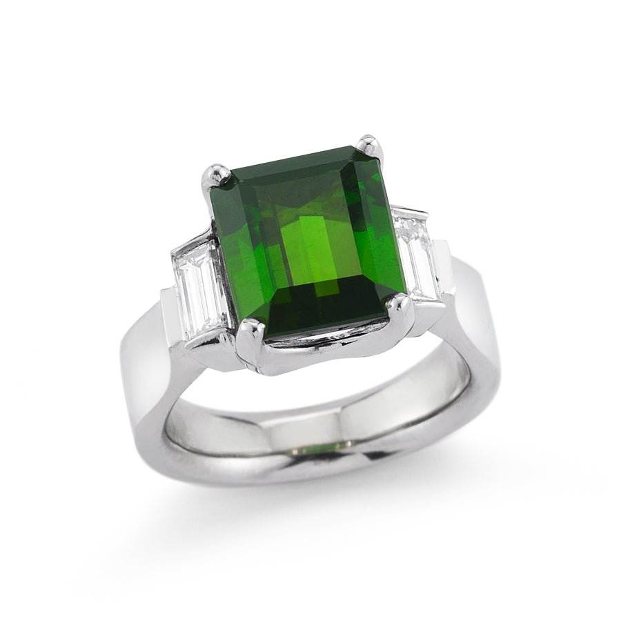 One-of-a-kind palladium ring featuring a 6.25-carat emerald-cut green tourmaline flanked by two step-cut baguette diamonds