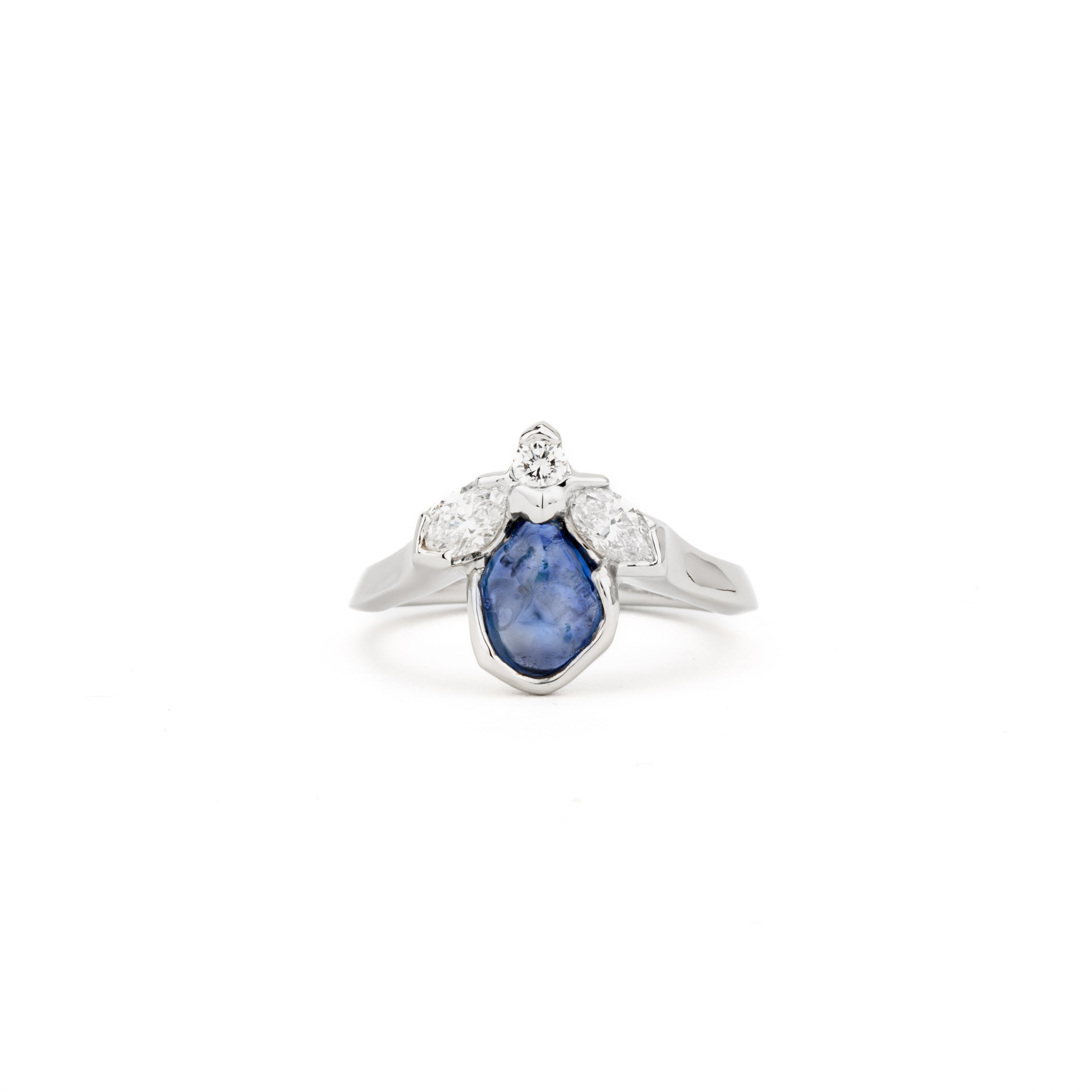 Freeform blue sapphire ring with marquise and round diamonds in white gold bezel setting