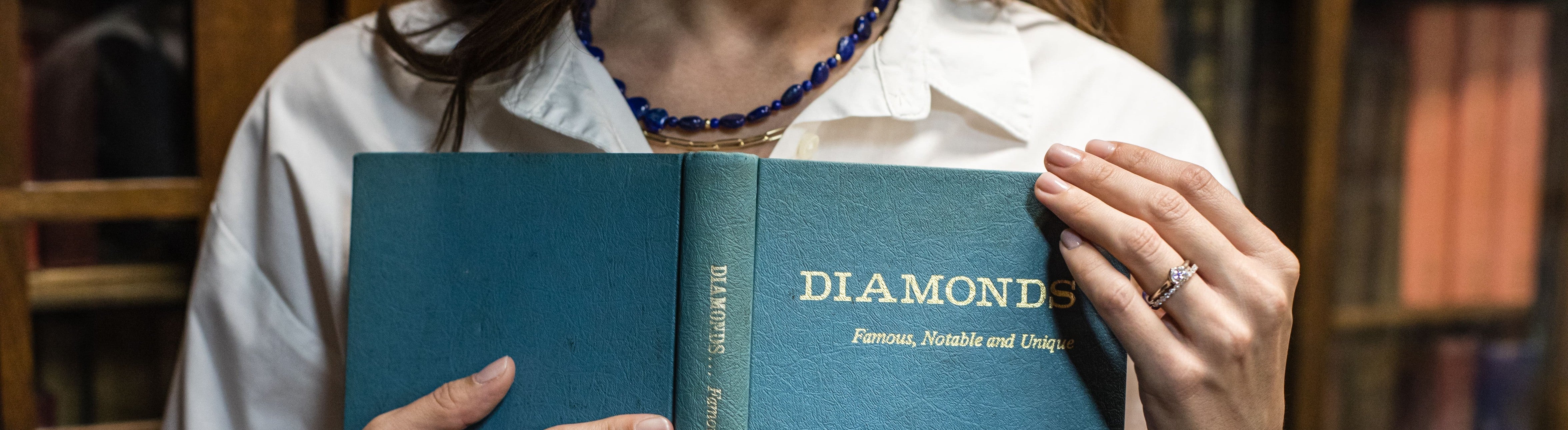 Girl holding a book titled Diamonds with jewelry