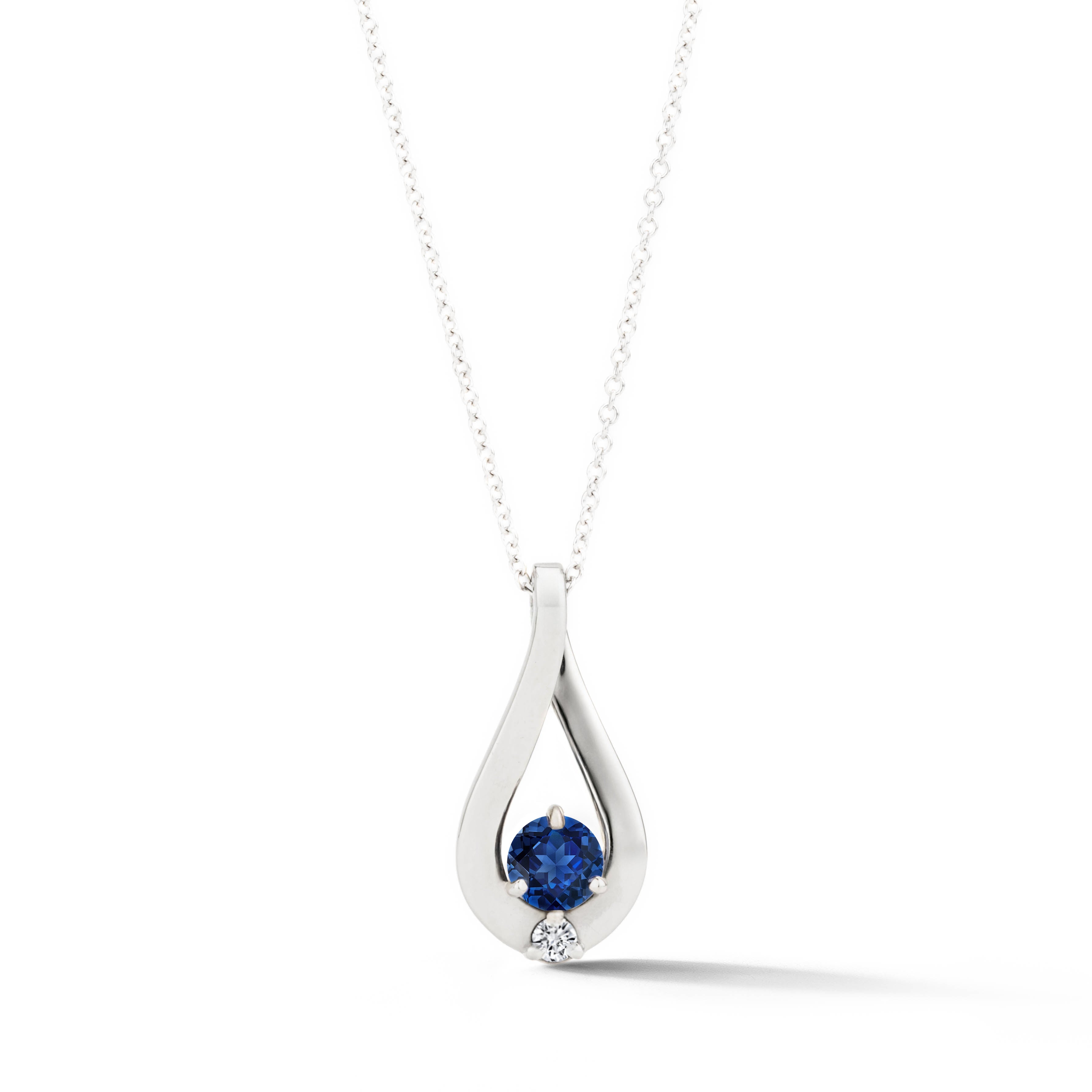 14k white gold twist pendant featuring a 0.58ct round brilliant sapphire and 0.04ct diamond accent