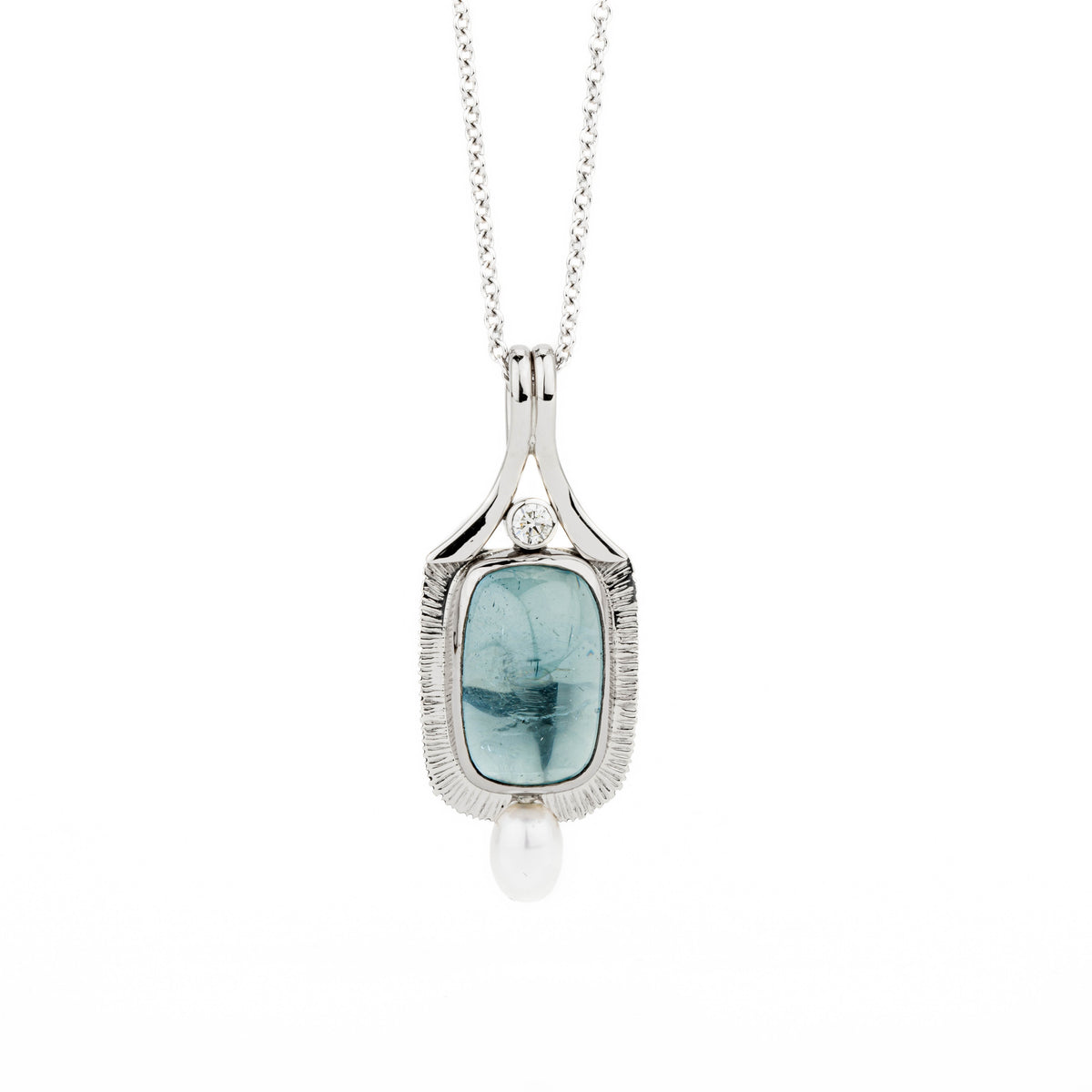 14k and 18k white gold pendant featuring a 7.82ct aquamarine cabochon in a hand-forged textured bezel, accented by a bezel-set diamond and freshwater pearl drop